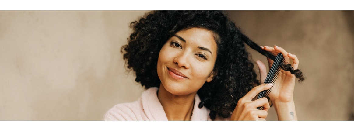 dunkelhaarige frau mit locken und kamm