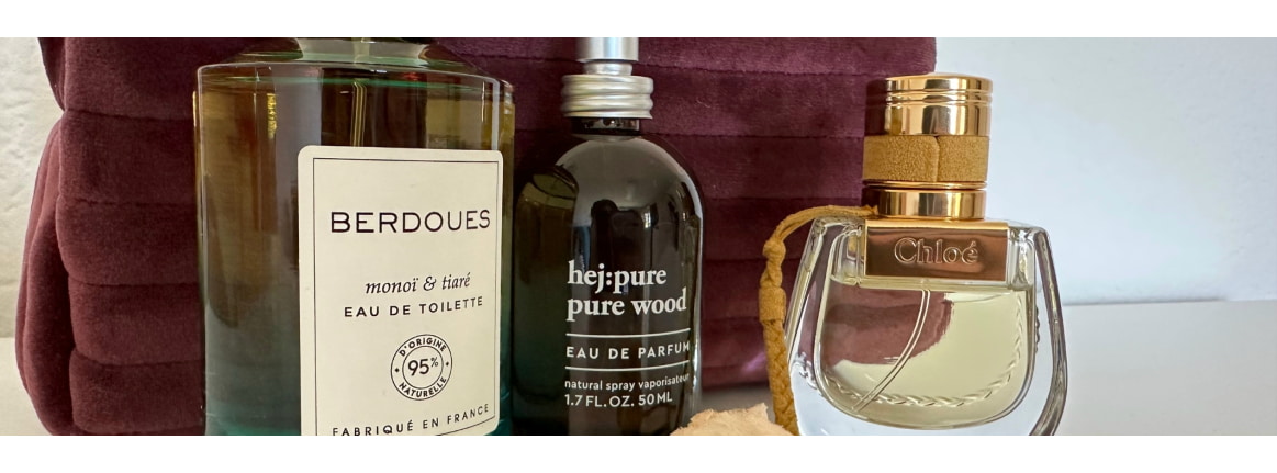 drei parfum flaschen auf tisch mit kosmetiktasche