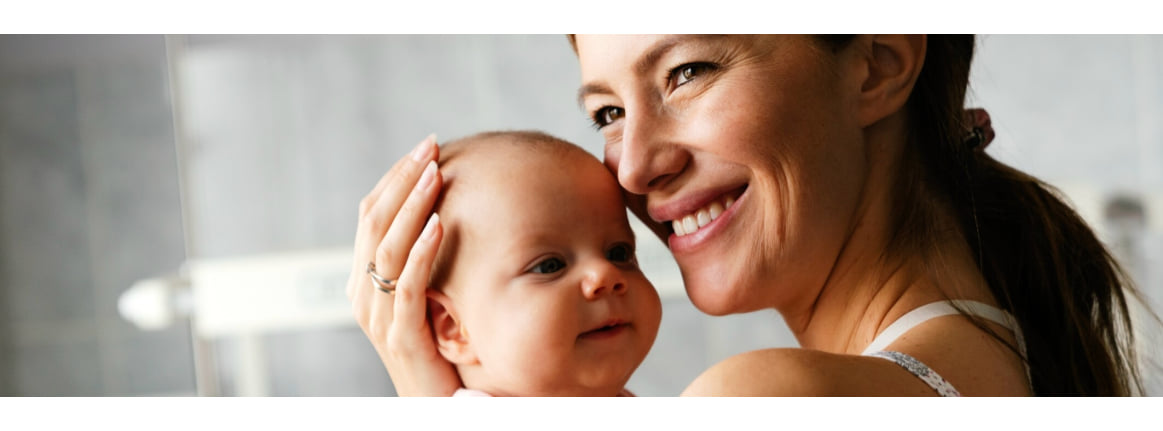 mutter haelt lachend baby in den armen