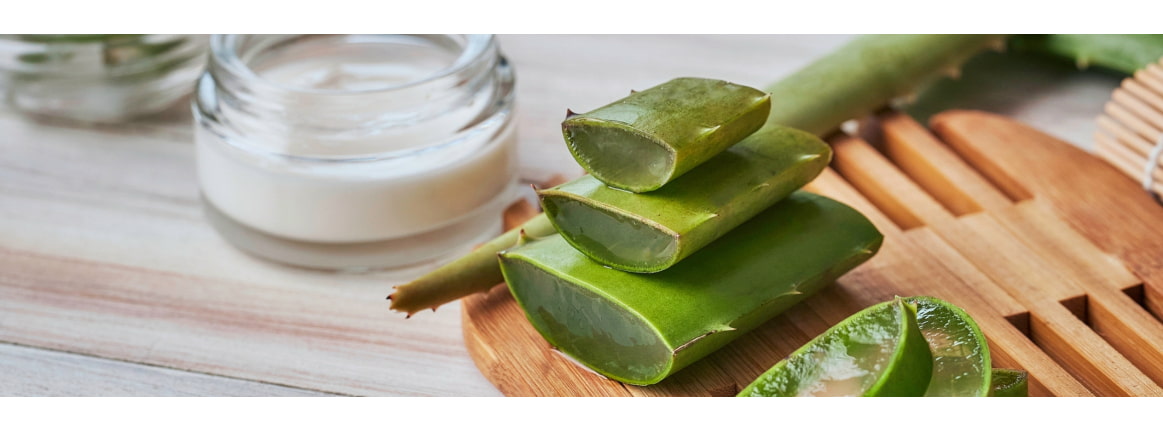 creme auf tisch mit geschnittenen aloe vera blaetter