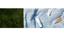 strandtuch auf rasen mit after sun produkten verteilt