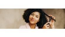 dunkelhaarige frau mit locken und kamm