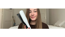 weisses haarglaetteisen ghd chronos max in der hand bei frau mit langem braunem haar
