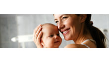mutter haelt lachend baby in den armen