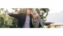 mann und frau im herbstlichen sonnenlicht schlendernd am see