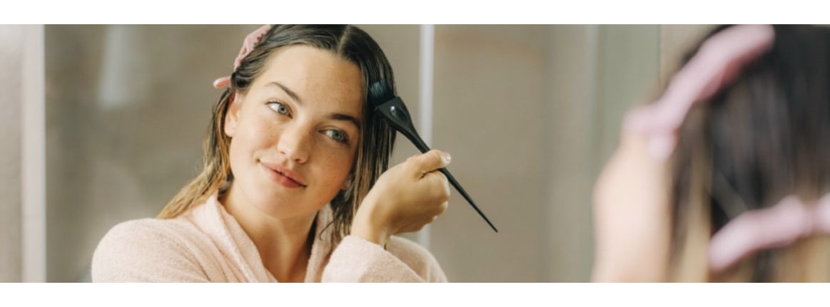 junge blonde frau mit farbpinsel am haar